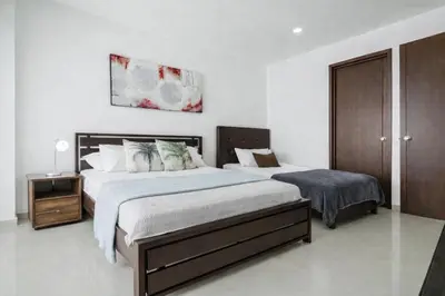 a bedroom with two beds and a night stand at Morros Flamingo Suite - con vista al mar y acceso a la playa in Cartagena de Indias