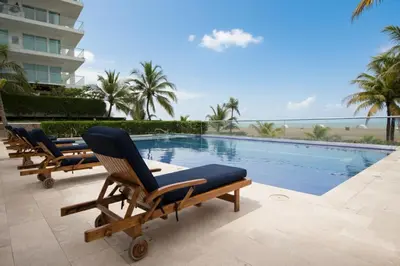 a row of lounge chairs next to a swimming pool at Morros Flamingo Suite - con vista al mar y acceso a la playa in Cartagena de Indias