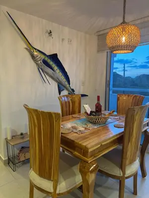a dining room table with a fish on the wall at Palo Rosa Caribe 202 in Coveñas