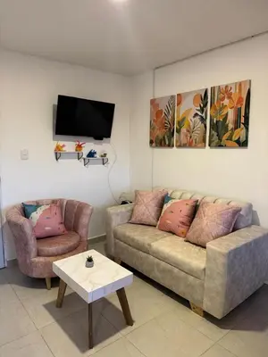 a living room with a couch and a table and a tv at Palo Rosa Caribe 202 in Coveñas