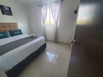 a small bedroom with a bed and a window at Suite hm caribe in Santa Marta