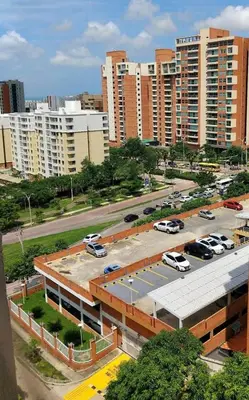 a parking lot with cars parked in front of buildings at APARTAMENTO-Miramar in Barranquilla