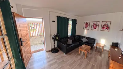 a living room with a black couch and a chair at Casa en el lago in Cartagena de Indias