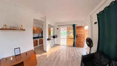 a living room with a wooden floor and a kitchen at Casa en el lago in Cartagena de Indias