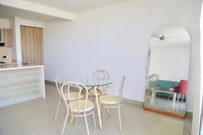 a dining room with a glass table and chairs at Apartamento en Riomar in Barranquilla