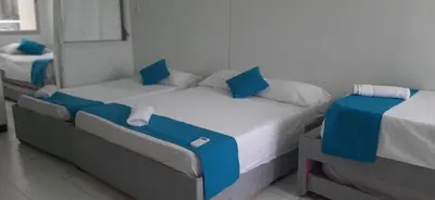 two beds with blue pillows in a room at Apartamento Tres Carabelas El Laguito in Cartagena de Indias