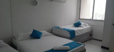 two beds in a small room with a window at Apartamento Tres Carabelas El Laguito in Cartagena de Indias