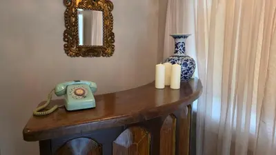 a table with a blue and white vase and a telephone at Hotel Casa La Tablada Aeropuerto in Cartagena de Indias