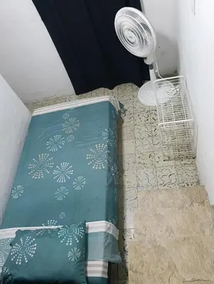 a bedroom with a bed with a fan on the floor at Habitación con medio baño en el barrio ciudad jardín Barranquilla in Barranquilla