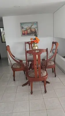 a table with two chairs and a vase on it at Habitación con medio baño en el barrio ciudad jardín Barranquilla in Barranquilla