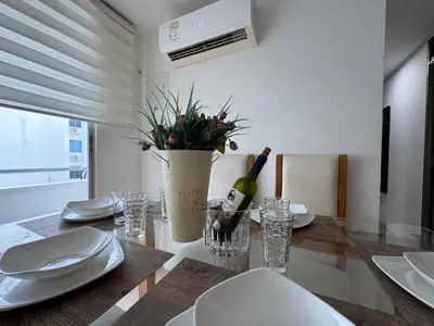 a dining room with a table with a bottle of wine at Conjunto Residencial Caribe Campestre in Coveñas