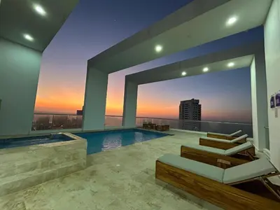 a house with a swimming pool with a sunset at Dúplex en Bocagrande Cartagena Piscina, jacuzzi y a 2 cuadras del mar in Cartagena de Indias