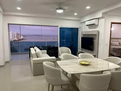 a living room with a table and chairs and a television at New apartment with a beautiful view 2002 in Cartagena de Indias