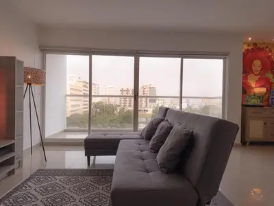 a living room with a couch and a large window at Stunning Caribbean-Inspired PH next to Viva Mall in Barranquilla