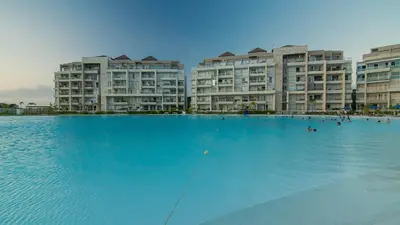 a large swimming pool in front of apartment buildings at Exclusive New 1-BR Apartment in Baia Kristal Kabo in Los Arrayanes