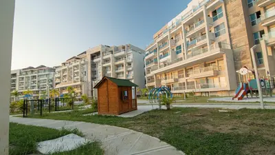 a small woodenshed in a park next to buildings at Exclusive New 1-BR Apartment in Baia Kristal Kabo in Los Arrayanes