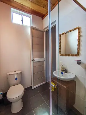 a bathroom with a toilet and a sink and a mirror at Villa Martina in Moñitos