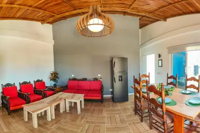 a living room with a table and red chairs at Villa Martina in Moñitos