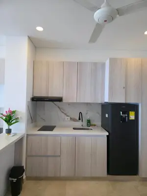 a kitchen with a black refrigerator and wooden cabinets at Relax vista al mar Aparta suite in Cartagena de Indias