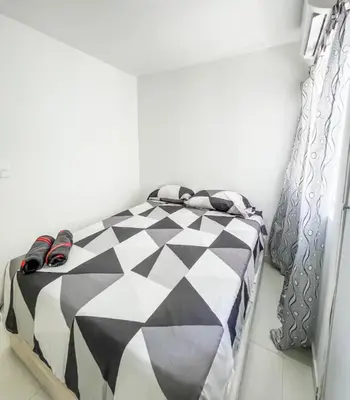 a bedroom with a black and white comforter on a bed at Apartamento 3 hab a paso del mar in Cartagena de Indias
