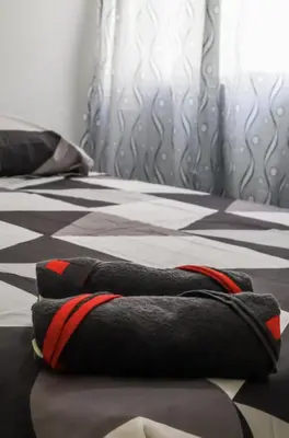 a bed with two black and red pillows on it at Apartamento 3 hab a paso del mar in Cartagena de Indias