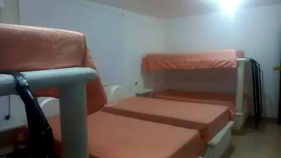 a room with two bunk beds and a chair at Cabaña Turística a Pasos del Mar, Ideal para Grupo in San Antero