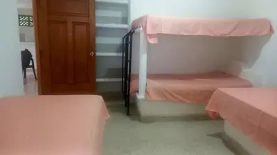 a room with two bunk beds and a door at Cabaña Turística a Pasos del Mar, Ideal para Grupo in San Antero