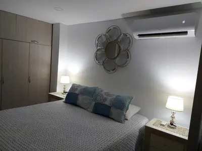 a bedroom with a bed and a mirror on the wall at Apartaestudio al frente del Mar in Cartagena de Indias