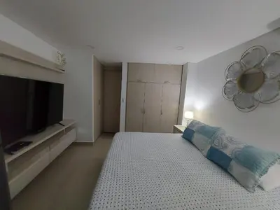 a bedroom with a large bed and a television at Apartaestudio al frente del Mar in Cartagena de Indias