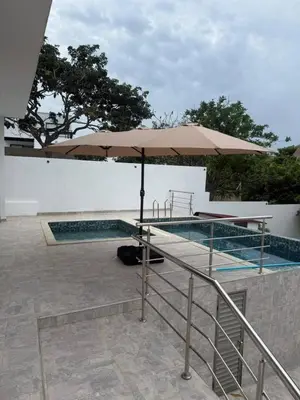 a swimming pool with an umbrella next to a swimming pool at Private pool cabin near the sea Puerto Velero in Tubará