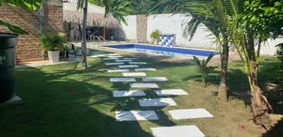 a garden with a pathway leading to a swimming pool at CABAÑA el EDEN in Santa Veronica
