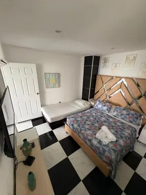 a bedroom with a bed and a checkered floor at MnM Vacation Rentals in Cartagena de Indias