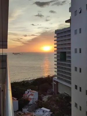 a sunset over the ocean from a hotel balcony at Apartaestudio con hotel y playa in Santa Marta