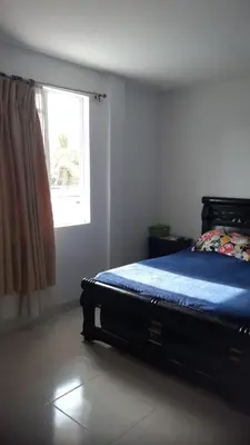 a bedroom with a bed with a blue blanket and a window at Apartamento Sector Torices in Cartagena de Indias