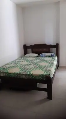 a bedroom with a bed with a green and white comforter at Apartamento Sector Torices in Cartagena de Indias