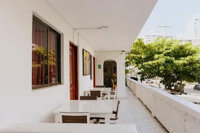 a white building with tables and chairs on a balcony at Hotel Ibatama in Cartagena de Indias