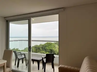a room with a sliding glass door with a table and chairs at Apartamento en Cielo Mar Cartagena in Cartagena de Indias