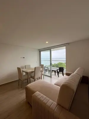 a living room with a couch and a table with chairs at Apartamento en Cielo Mar Cartagena in Cartagena de Indias