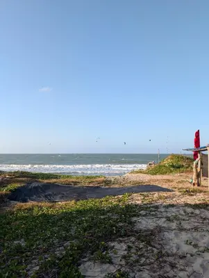 a person holding a surfboard on the beach at Guacamaya Kite Lodges in Salina de Rey