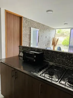 a kitchen with a stove and a counter top at cool and quiet apartment in front of the urban forest in Barranquilla