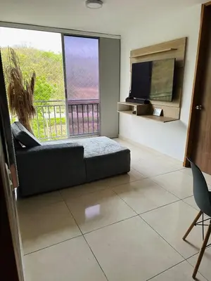 a living room with a bed and a large window at cool and quiet apartment in front of the urban forest in Barranquilla