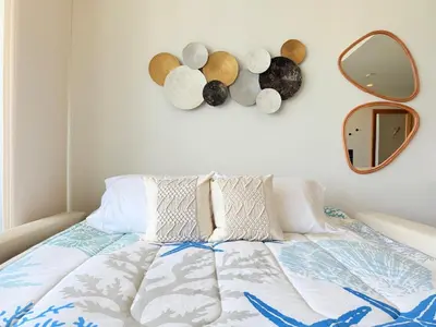 a bed with pillows and a mirror on a wall at Magnificent Apartment - Beach - Jacuzzis! in Cartagena de Indias