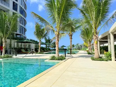 a swimming pool with palm trees next to a building at Magnificent Apartment - Beach - Jacuzzis! in Cartagena de Indias