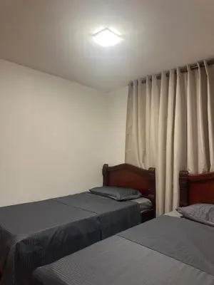 a bedroom with two beds and a curtain at Comfortable and nice apartment in Barranquilla