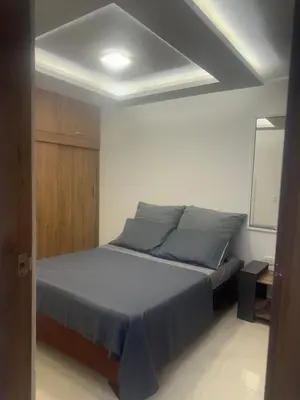 a bedroom with a bed and a white wall at Comfortable and nice apartment in Barranquilla