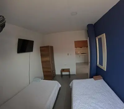 a small room with two beds and a tv at Cartagena loft apartment near historic center in Cartagena de Indias