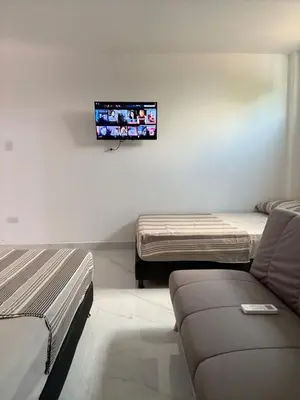 a room with two beds and a tv on the wall at Maru apartamentos #5 in Cartagena de Indias