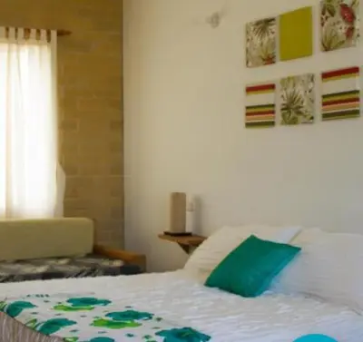 a bedroom with a bed with a green pillow on it at Apartamentos frente al Mary Tolu - Coveñas in San Silvestre