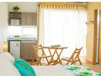 a bedroom with a bed and a kitchen with a table at Apartamentos frente al Mary Tolu - Coveñas in San Silvestre