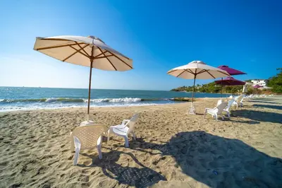 a row of chairs and umbrellas on a beach at Hotel Santorini Casablanca Resort in Santa Marta
